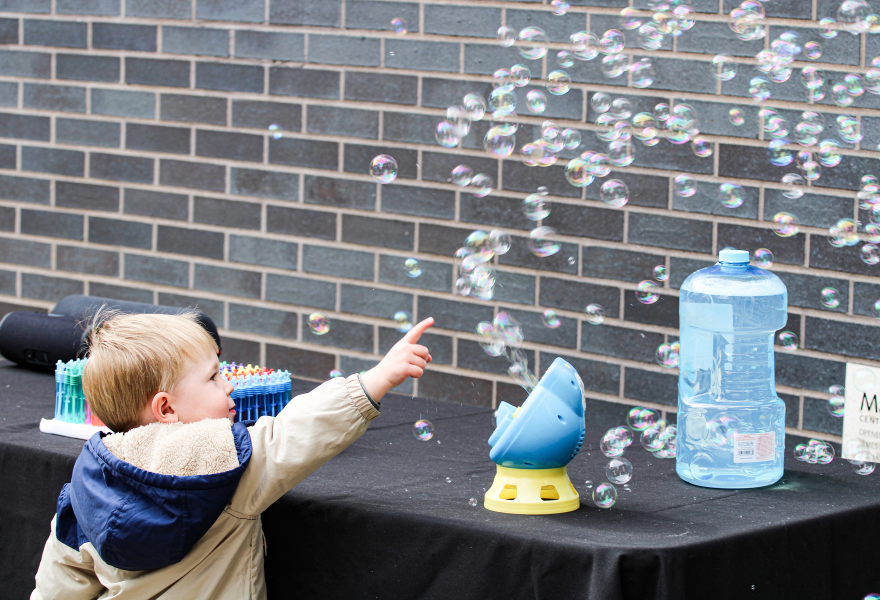 A young child plays with bubbles at the MacPhail Block Party.