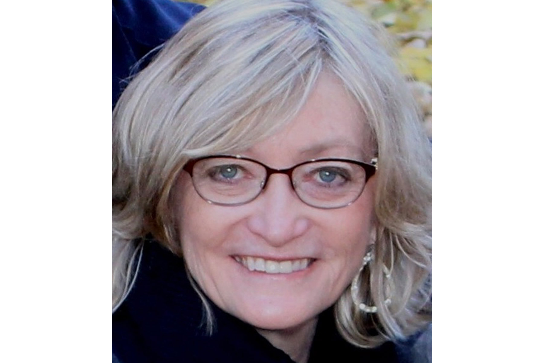 Headshot of Lou Ann Henderson. She has short hair and wears black glasses.