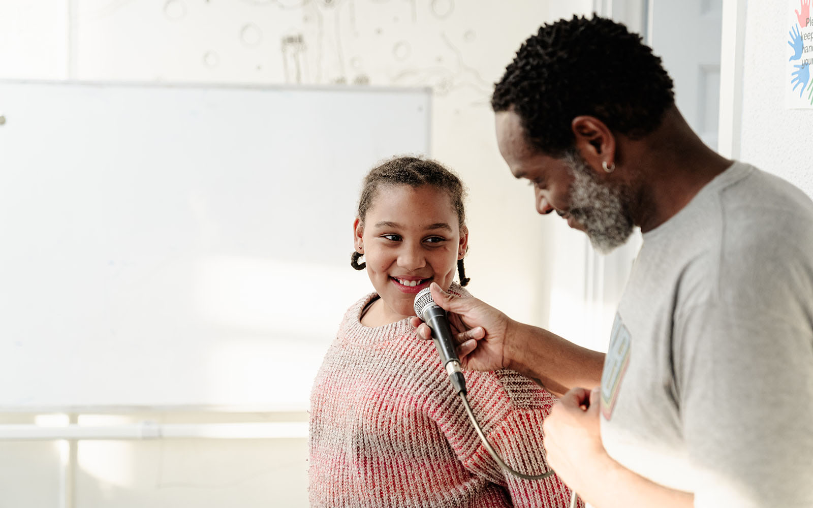 Beatboxer Terrell Woods holding a microphone to a young girl